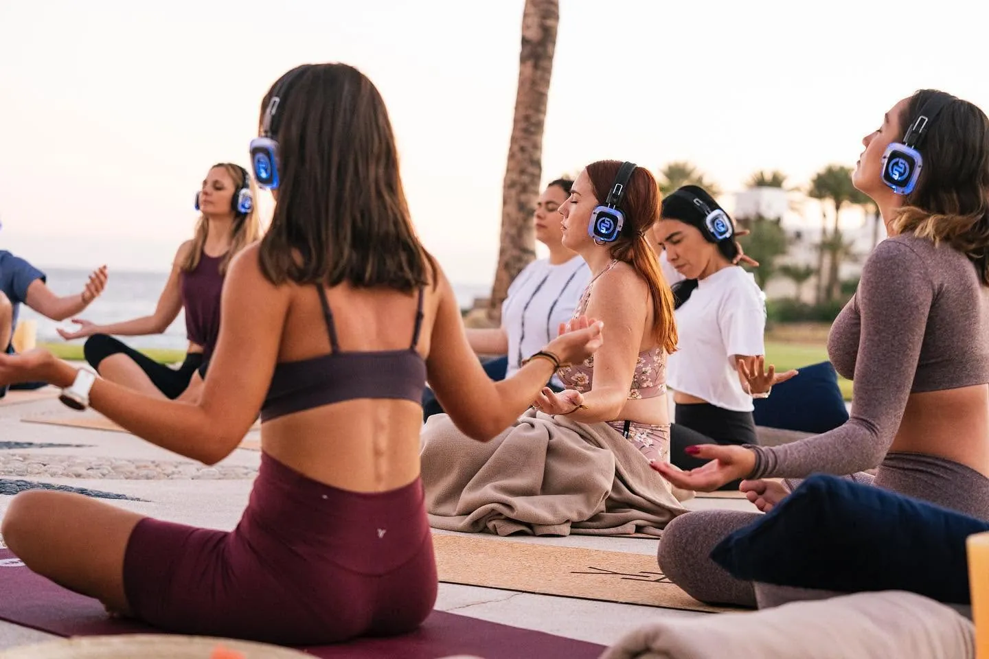 Meditazione al tramonto in un resort, con cuffie wireless luminose